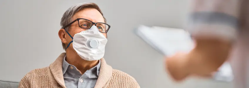 doente de máscara a receber informação clínica