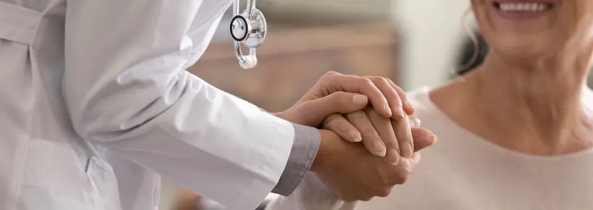 médico dá a mão a paciente