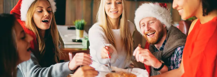 várias pessoas a partilharem um doce de natal