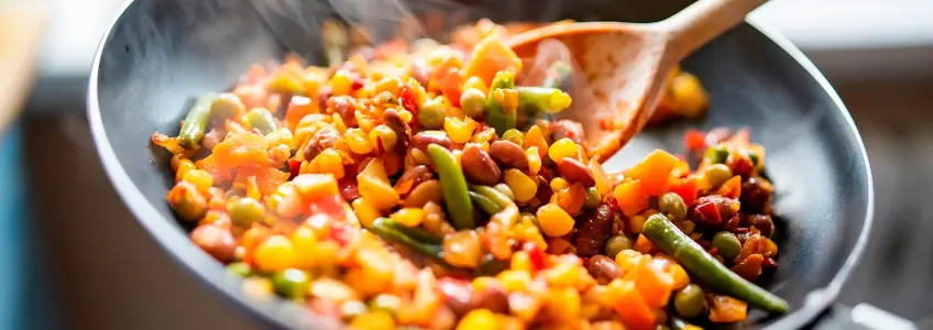 pessoa a saltear legumes e leguminosas