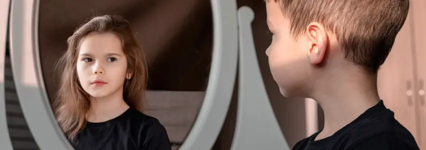 menino vê menina refletida no espelho