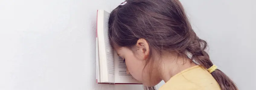menina com cabeça encostada a livro