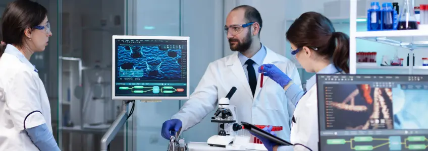 três técnicos analisam resultados em laboratório