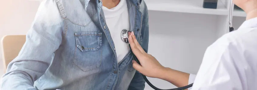 médica a auscultar paciente
