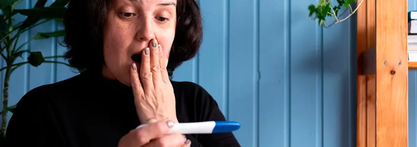 mulher surpreendida com resultado de teste de gravidez