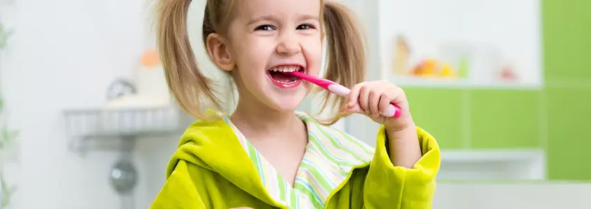 menina a lavar os dentes contente