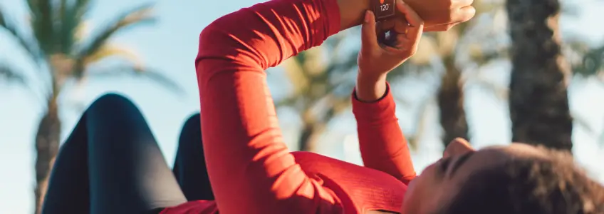 mulher pós-treino deitada a medir o ritmo cardiaco