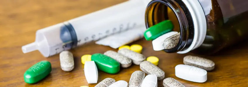 vários medicamentos e seringa numa mesa