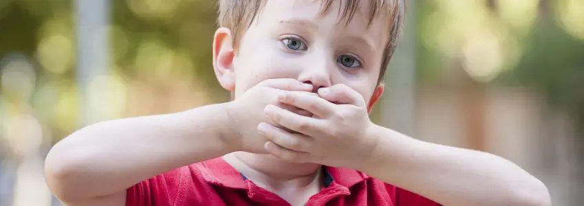 menino a tapar a boca com as mãos