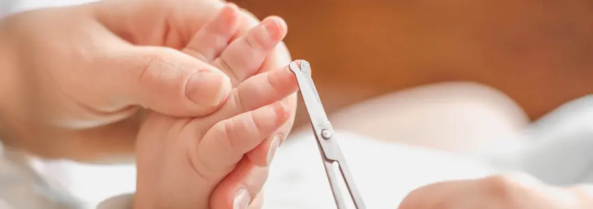mãe a cortar unhas das mãos a filho