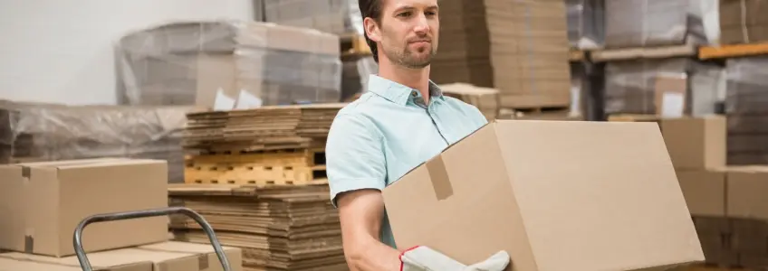 homem a carregar uma caixa pesada no trabalho