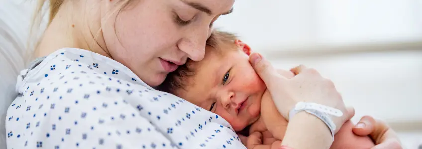 mão de mãe a segurar mão de bebé recém-nascido