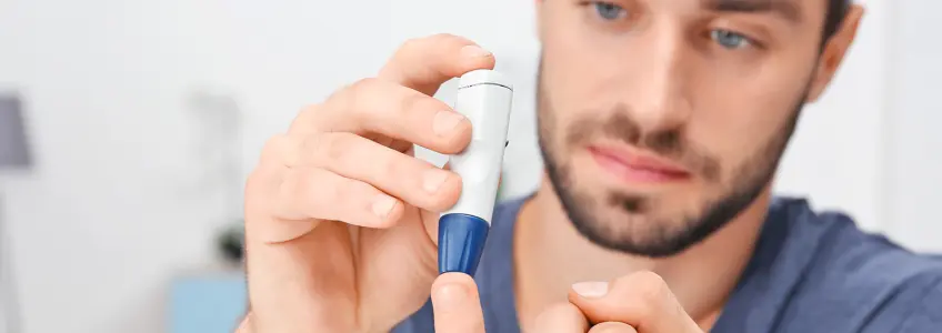 rapaz com diabetes a tirar amostra de sangue com uma lanceta