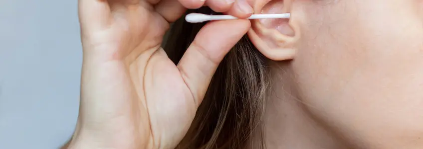 mulher a limpar ouvidos com um cotonete