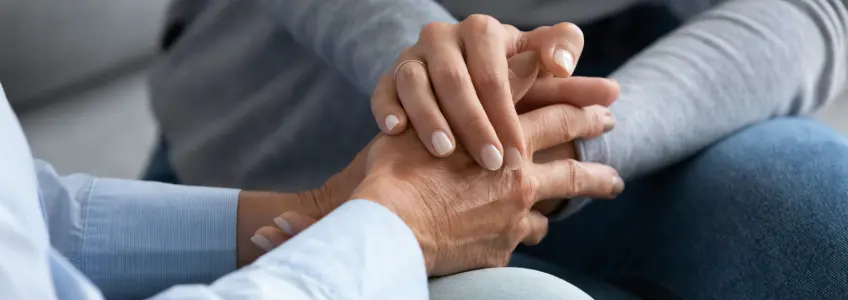 amigas reconfortam-se, dando as mãos