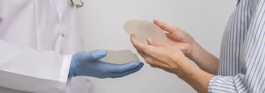 médico e paciente seguram em implantes de silicone