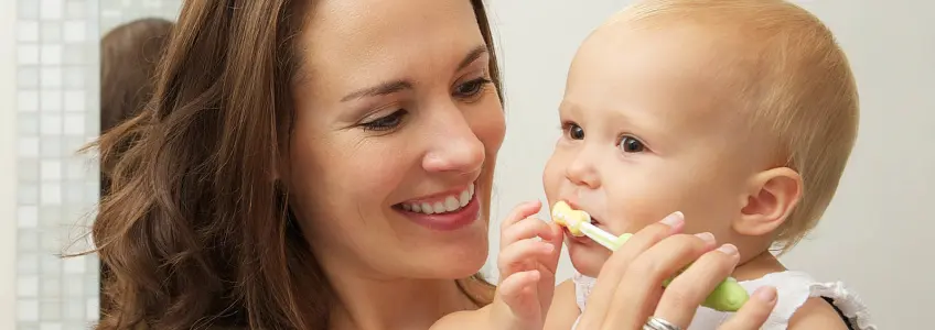 mãe a escovar dentes da filha