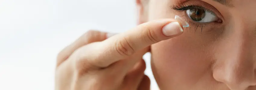 rapariga a colocar lentes de contacto
