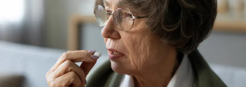senhora a tomar um comprimido de amoxicilina