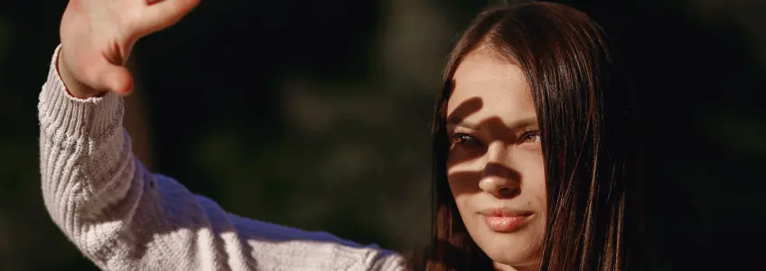rapariga encandeada com a luz solar