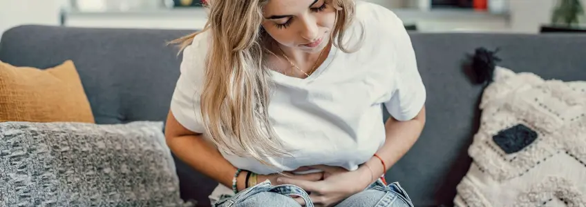 mulher com desconforto abdominal