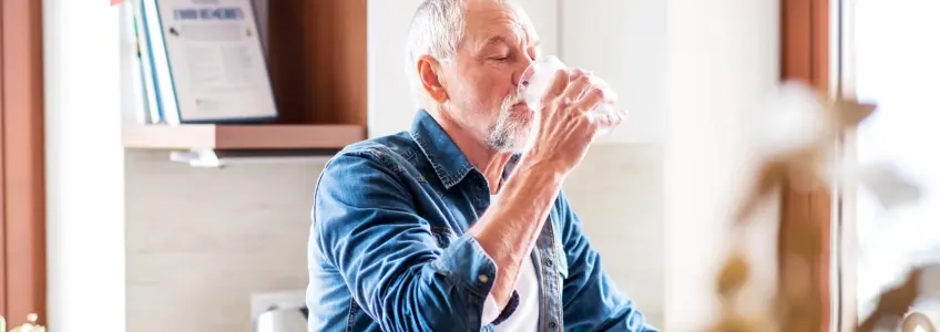 senhor a beber um copo com água