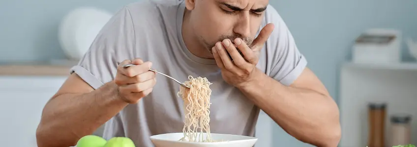 homem a ingerir uma grande quantidade de esparguete