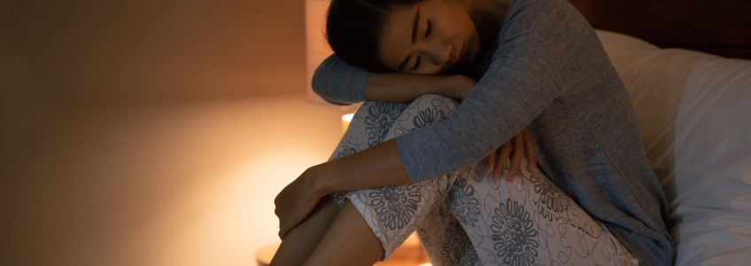 Mulher a agarrada às pernas sem conseguir dormir 