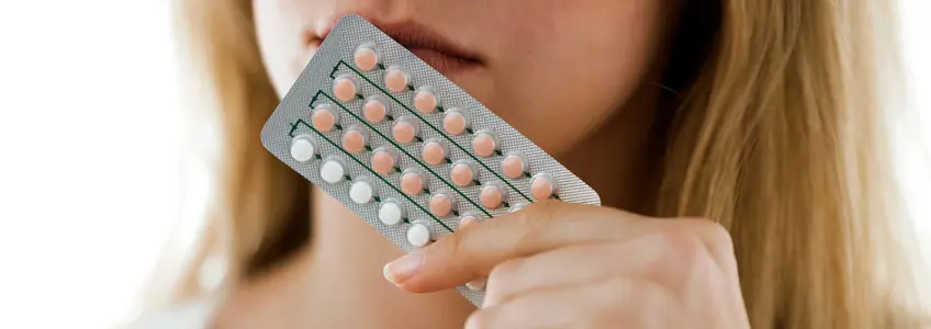mulher a segurar numa embalagem de pílulas