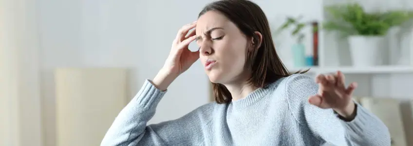 mulher com olhos fechados e mão na cabeça