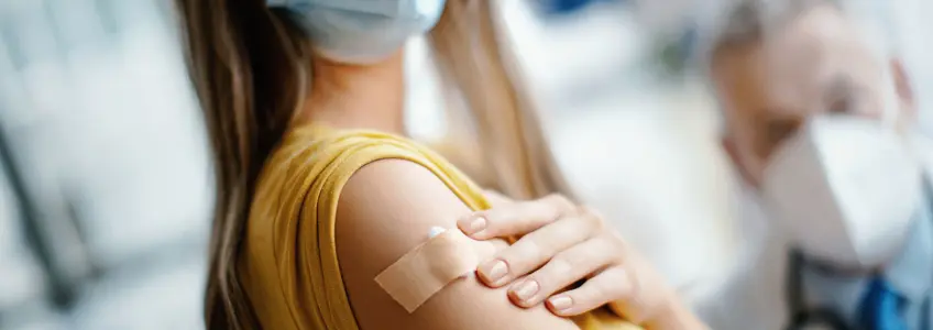 mulher com penso rápido no braço após vacinação