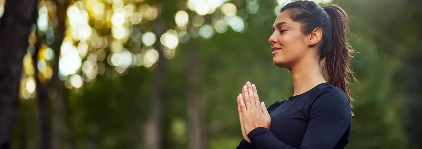 jovem rapariga a meditar ao ar livre
