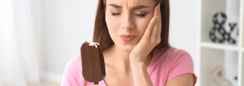 rapariga sente dor nos dentes ao comer um gelado