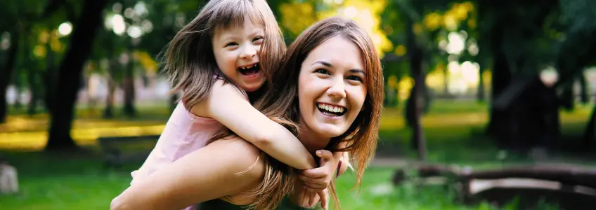 mãe com menino com Síndrome de down às cavalitas