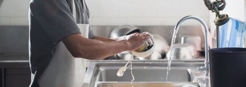 Homem a lavar utensílios de cozinha
