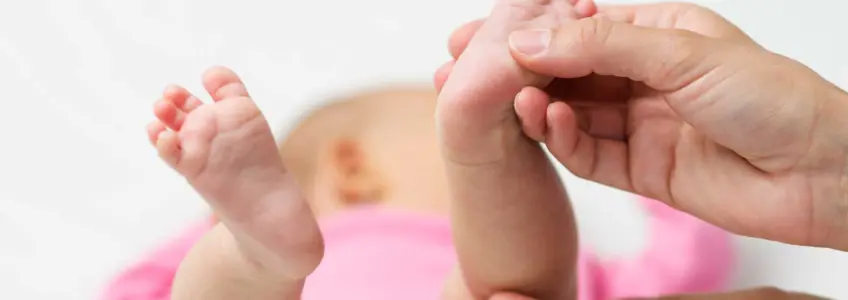 mãe a segurar pezinho do bebé