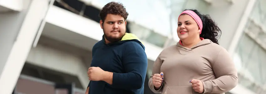 dois jovens com excesso de peso a fazer exercício físico