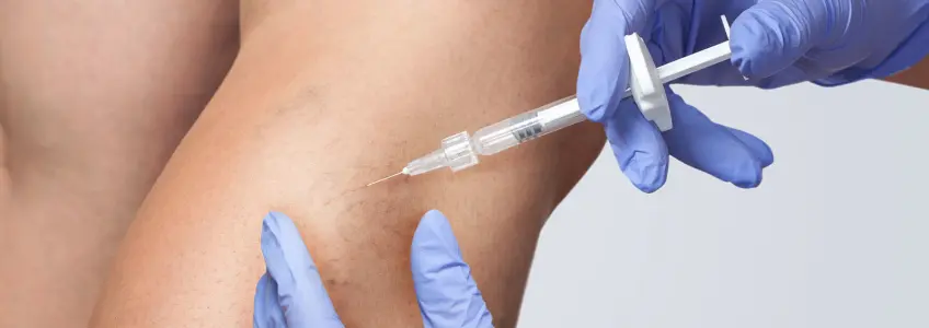 enfermeira a medicar a perna da paciente