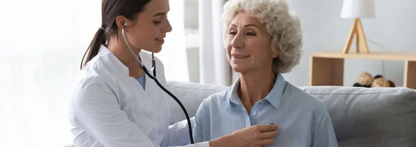 médica a auscultar paciente mulher