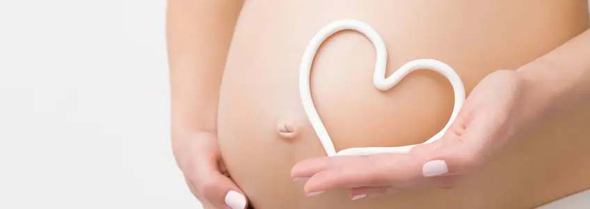 creme forma um coração na barriga de grávida